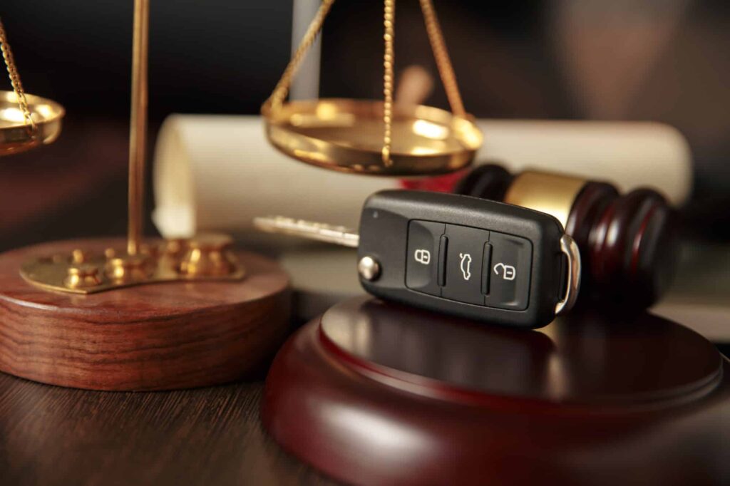 finding a car accident attorney in boston lawyers desk with car keys with a gavel and scale