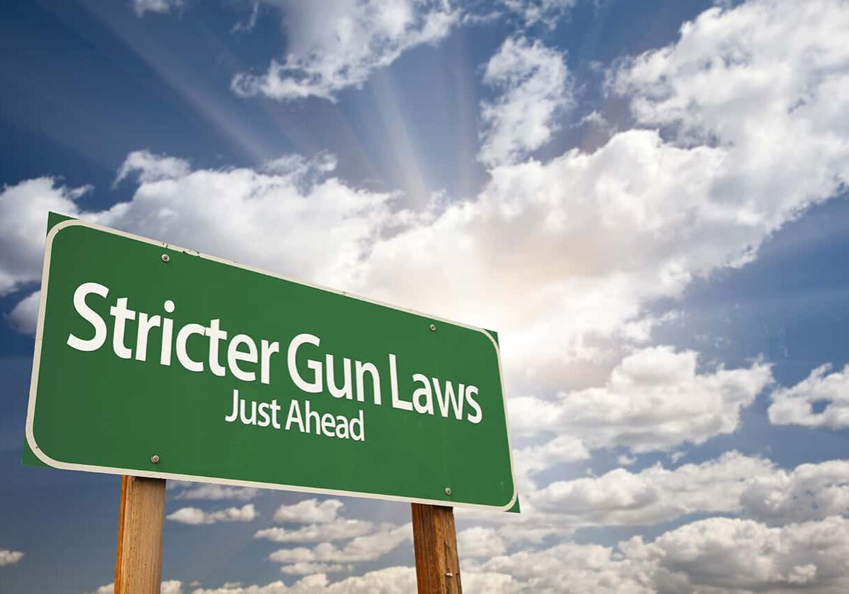 road sign with stricter gun laws just ahead written